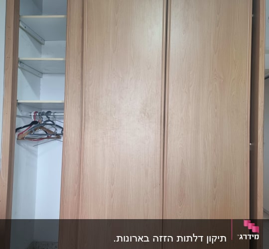 ארון עץ עם דלתות הזזה פתוחות למחצה
